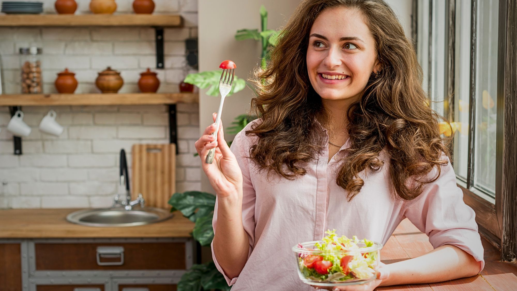 A woman holds a fresh salad in her hand, showcasing a healthy and appetizing delicious meals option from takeaway Stockport.